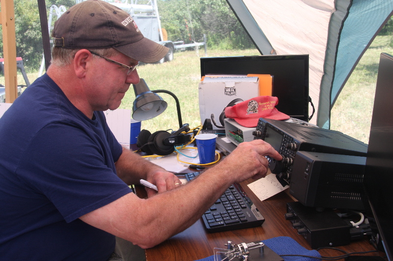 Leo K1LK at an HF radio with CW paddles at the ready